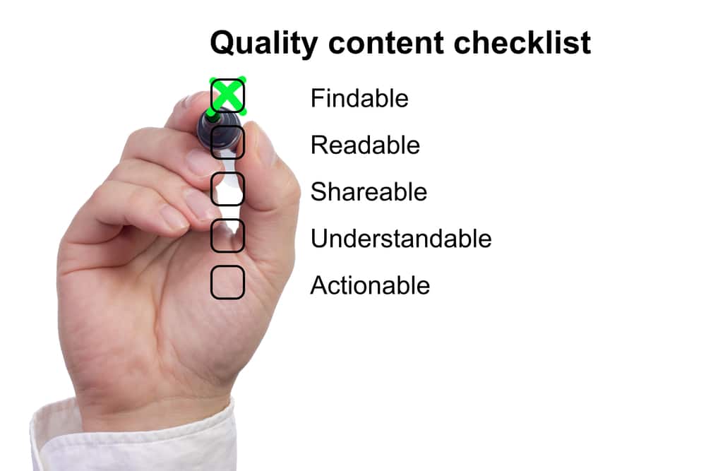 "Hand checking off items on a quality content checklist including readability and shareability."